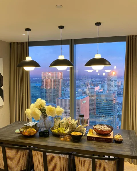 Three illuminated pendant lights above a dining table at Landmark Pinnacle